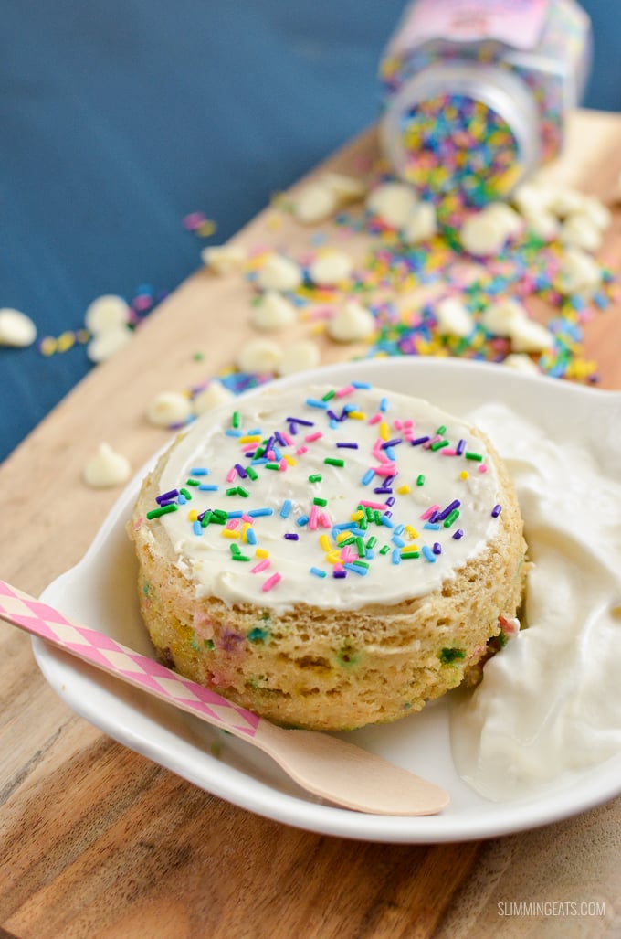 Funfetti Birthday Cake Mug Cake - a delicious vanilla flavour cake scattered with rainbow sprinkles and topped with white chocolate all cooked in a mug in the microwave in just a few minutes. Slimming World and Weight Watchers friendly | www.slimmingeats.com