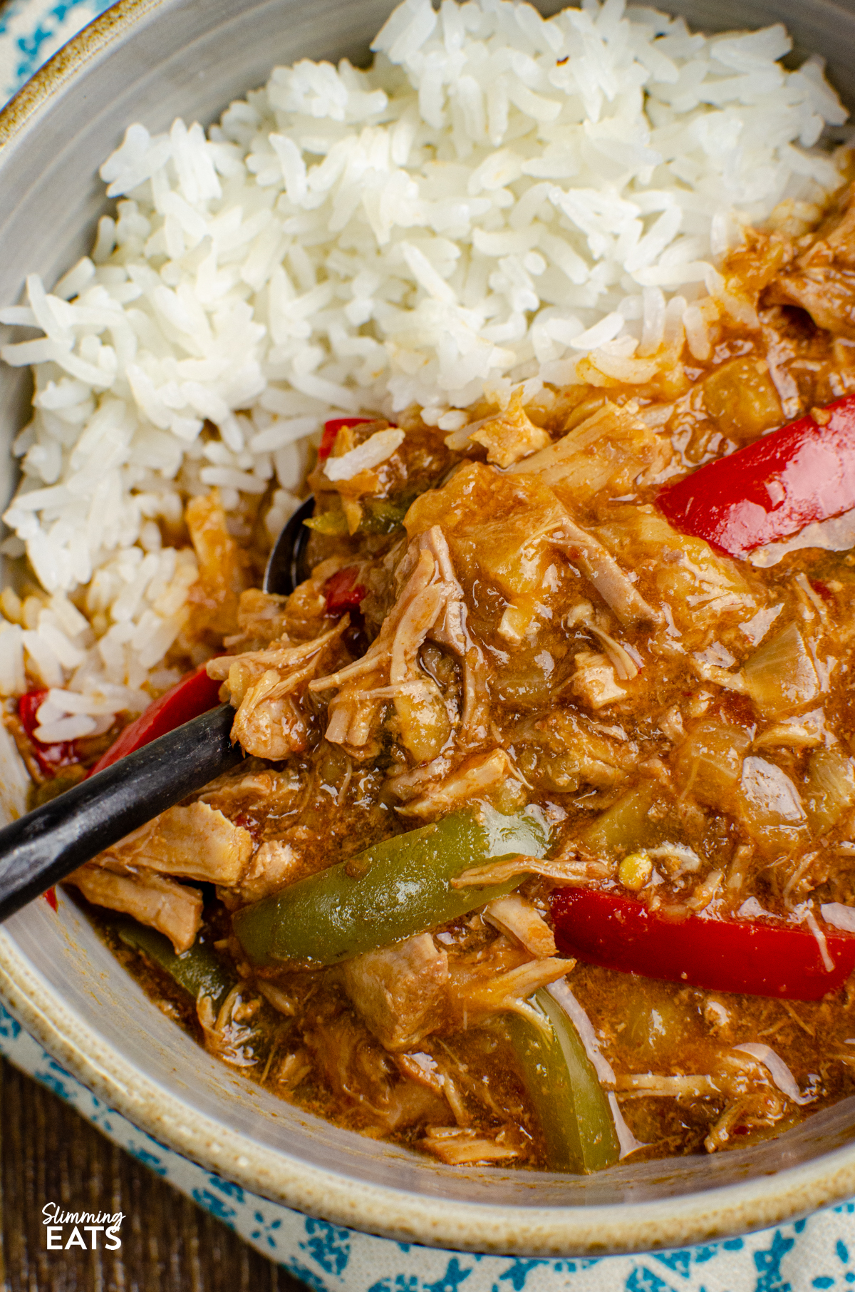 Slow Cooker Pineapple Pork - tender slow cooked pork in a delicious sweet and savoury sauce with pineapple, peppers, soy sauce and a little kick of spice. It is the perfect easy dinner that is ideal for busy days when you want dinner ready and waiting for you when you get home. close up of serving of Slow Cooker Pineapple Pork with rice