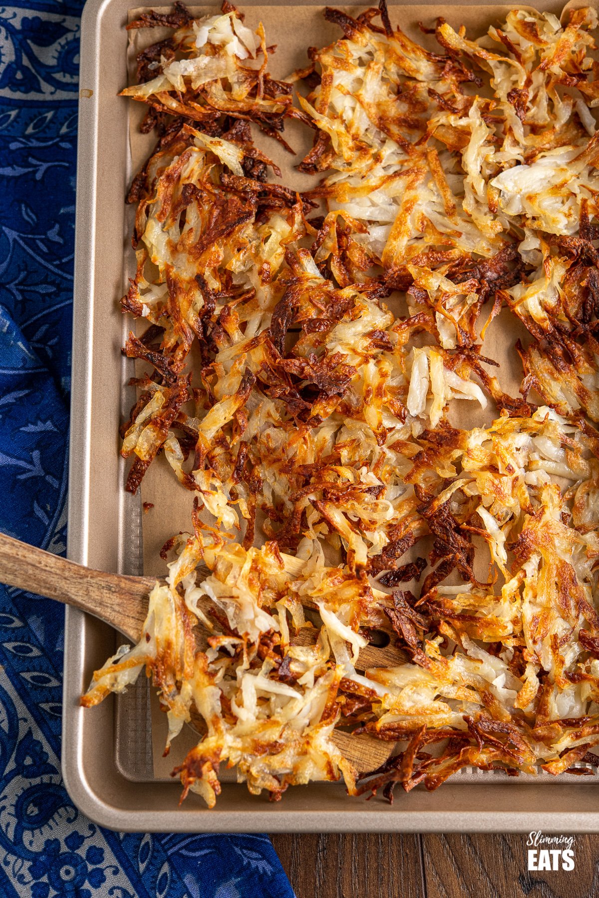 Sheet Pan American Crispy Hash Browns - the perfect side for when you fancy a filling breakfast and perfect with eggs, bacon or sausage. #potatoes #hashbrowns #slimming #weightwatchers #vegan #vegetarian #glutenfree #dairyfree shredded potato hash browns on baking tray