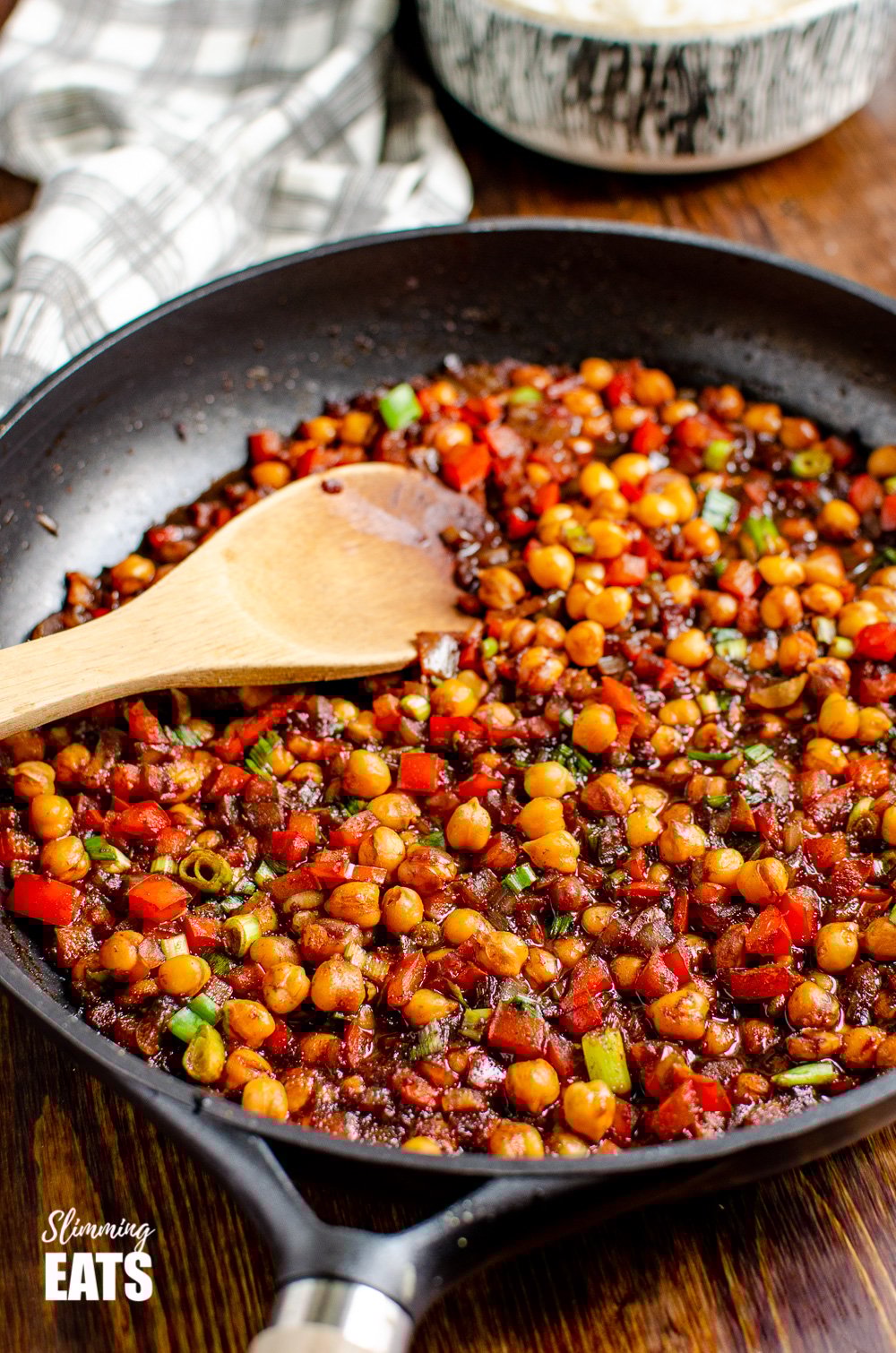 Chinese 5 spice Chickpeas - the perfect quick and easy recipe for anyone looking for a meat-free Chinese Fakeaway meal. Gluten free, dairy free, vegan, Slimming Eats and Weight Watcher friendly Chinese 5 spice Chickpeas in black frying pan with wooden spoon on wooden board