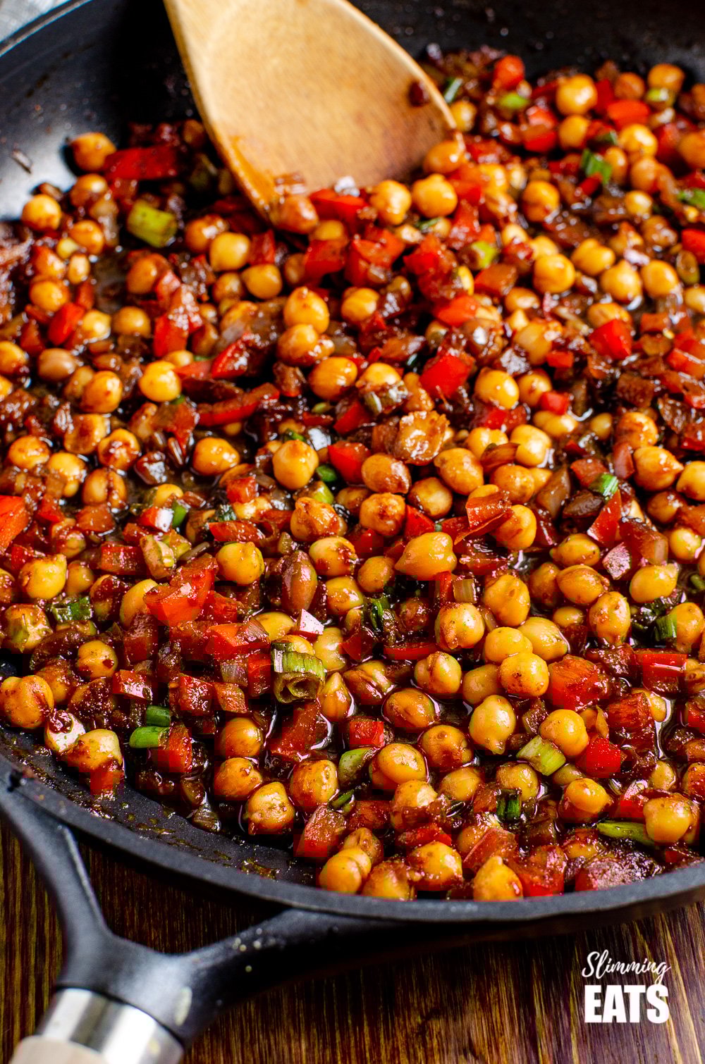 Chinese 5 spice Chickpeas - the perfect quick and easy recipe for anyone looking for a meat-free Chinese Fakeaway meal. Gluten free, dairy free, vegan, Slimming Eats and Weight Watcher friendly close up Chinese 5 spice Chickpeas in black frying pan with wooden spoon