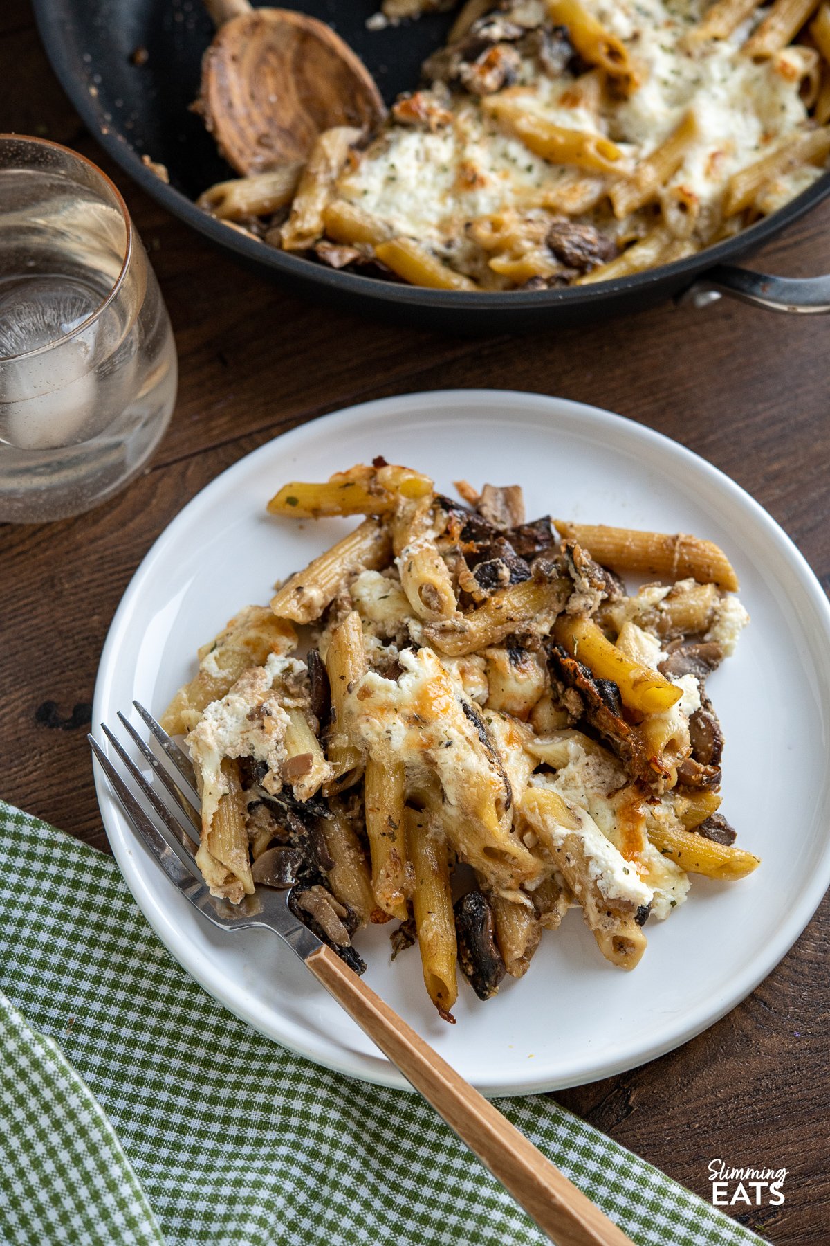 serving of Baked Garlic Mushroom and Ricotta Pasta on a white plate with fork placed to the side