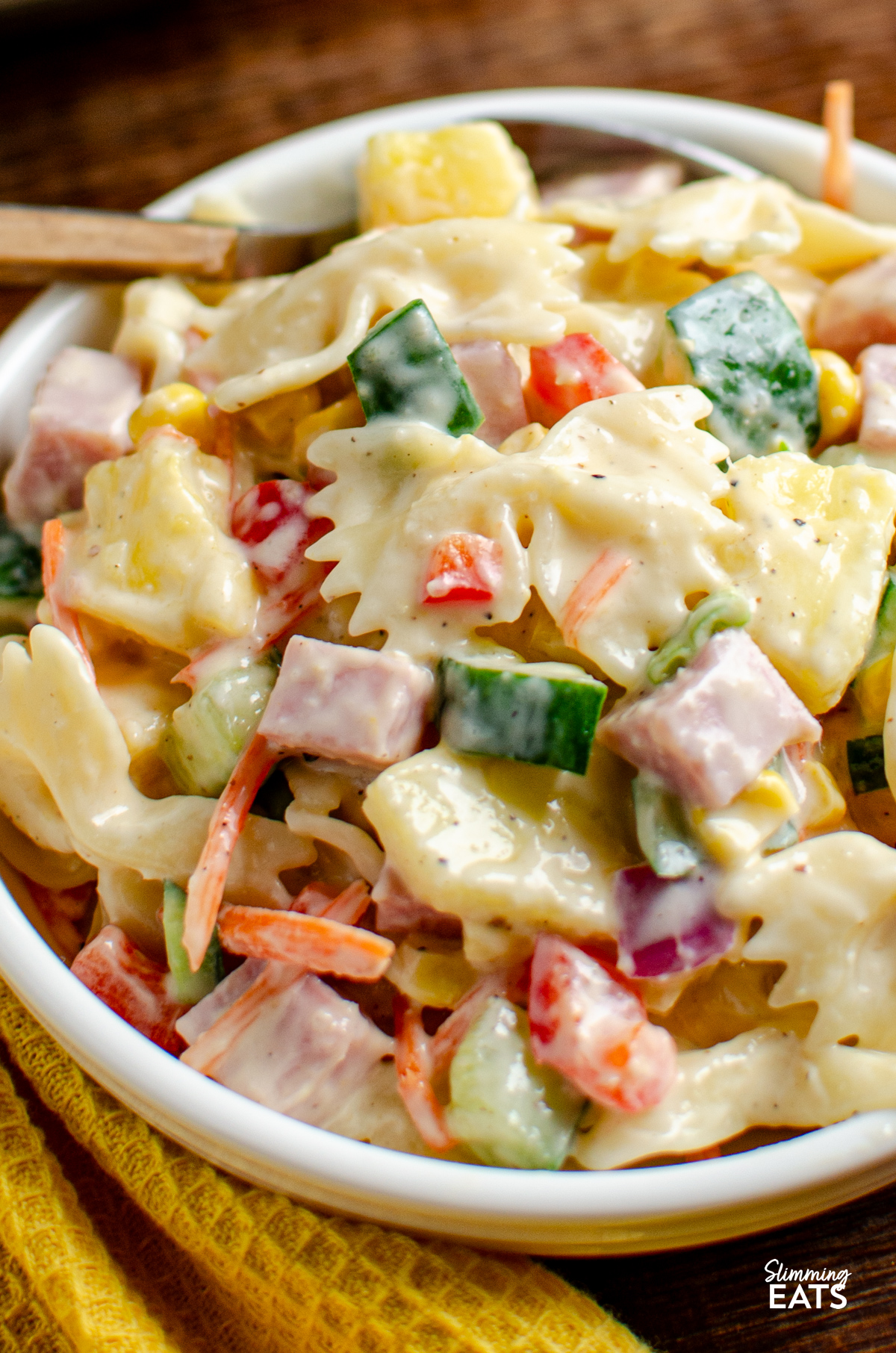 This Hawaiian Pasta Salad is a fresh, creamy and colourful side dish packed with ham, pineapple and crunchy vegetables, perfect for barbecues, picnics or easy lunches. close up of serving of hawaiian pasta salad in a white bowl.