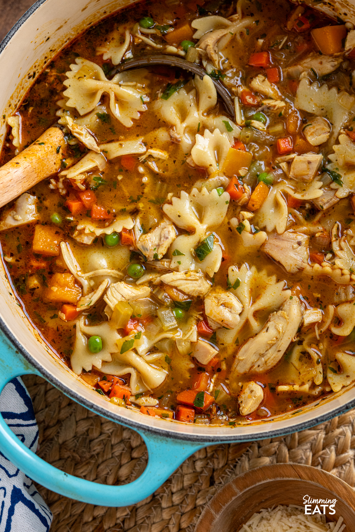 close up of Chicken Vegetable Pasta Soup in turquoise cast iron pot with ladle