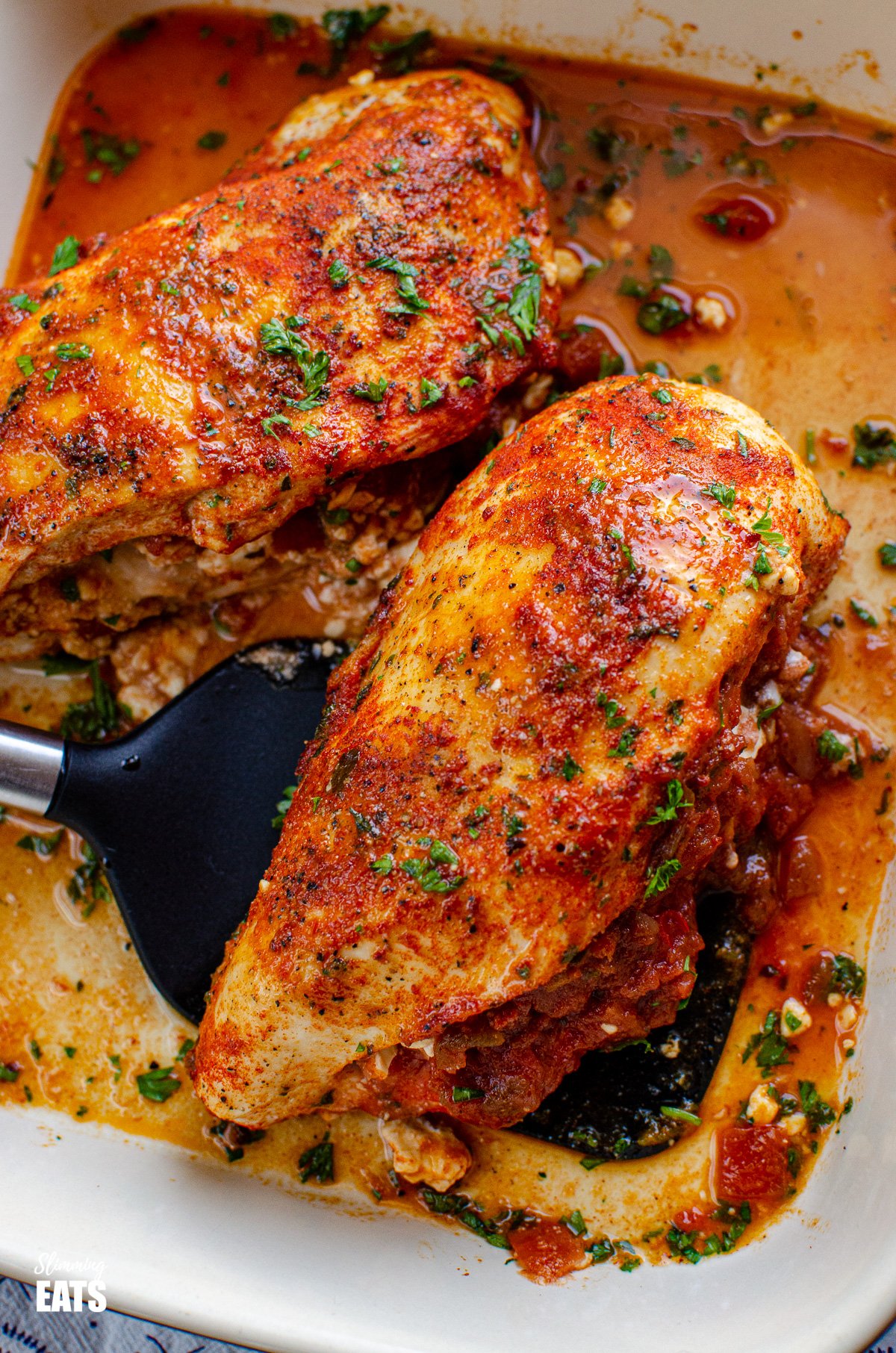 close up of Spicy Chicken Stuffed with Feta Cheese and Salsa in baking dish