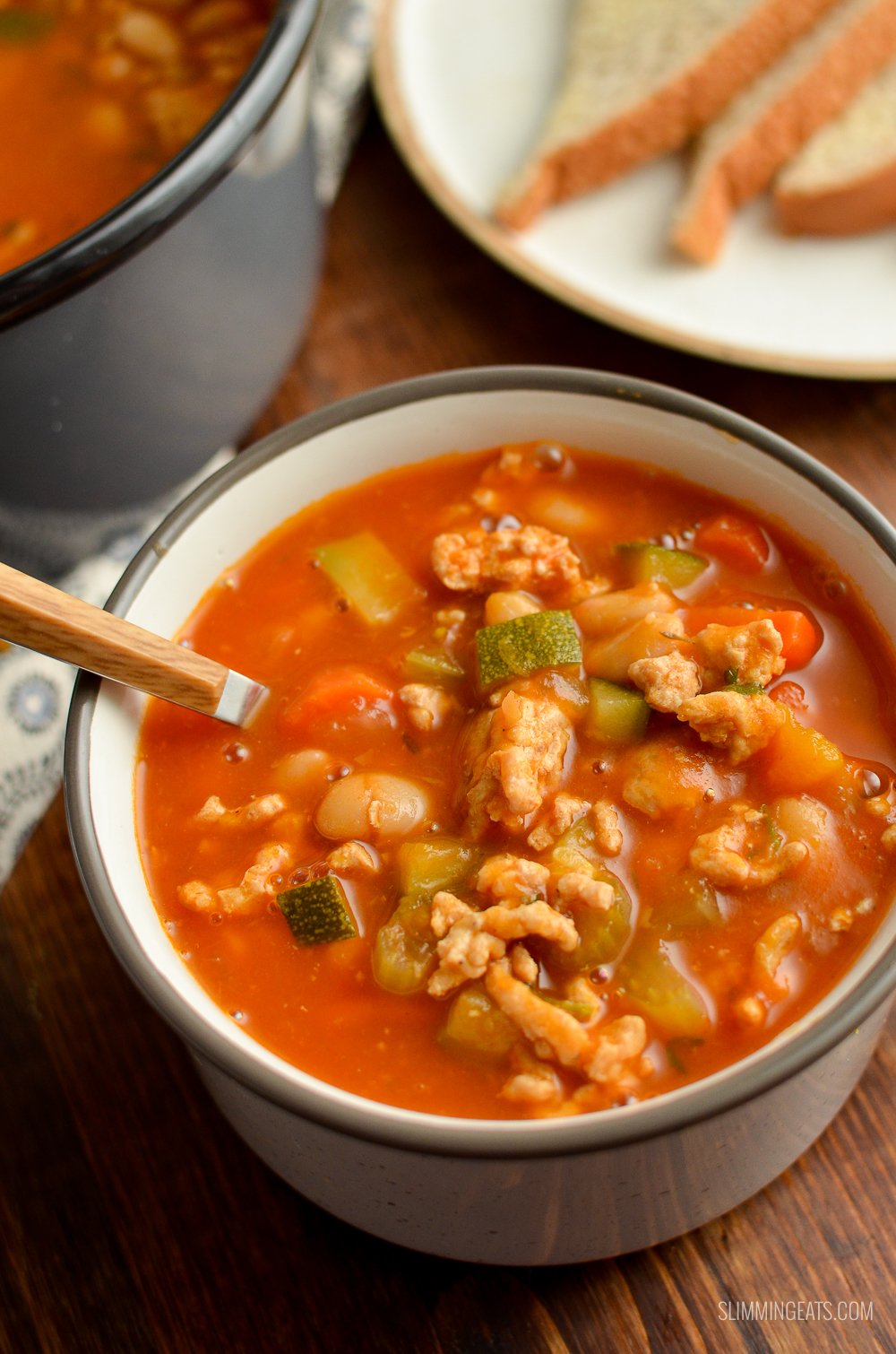 spoon in a soup cup filled with ground turkey vegetable bean soup