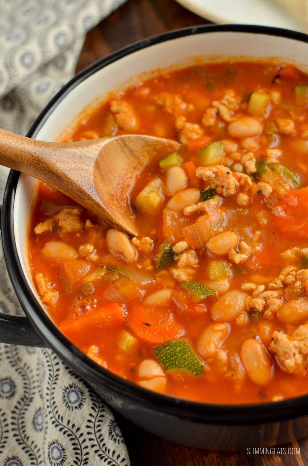 ground turkey vegetable bean soup in grey saucepan with wooden spoon