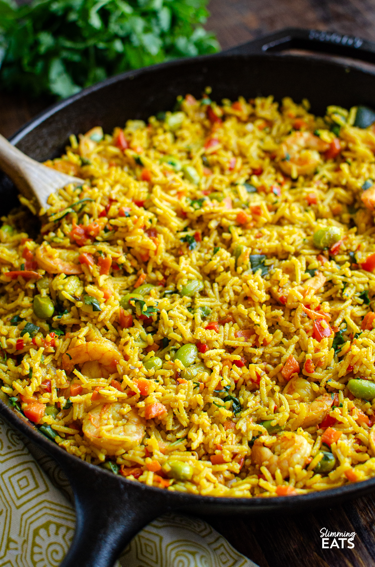 One Pot Prawn and Vegetable Pilaf in skillet with wooden spoon 
