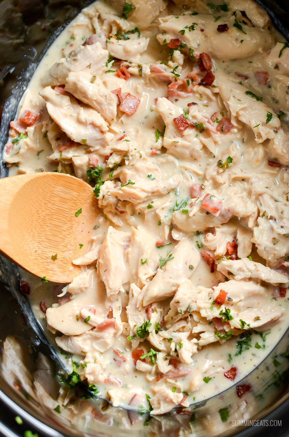 Healthier Slow Cooker Crack Chicken - the ultimate family-friendly creamy chicken recipe topped with the yummy smokey flavour of bacon. Oh my!! #slimming #weightwatchers #chicken #slowcooker #glutenfree #bacon #creamy slow cooker crack chicken with wooden spoon