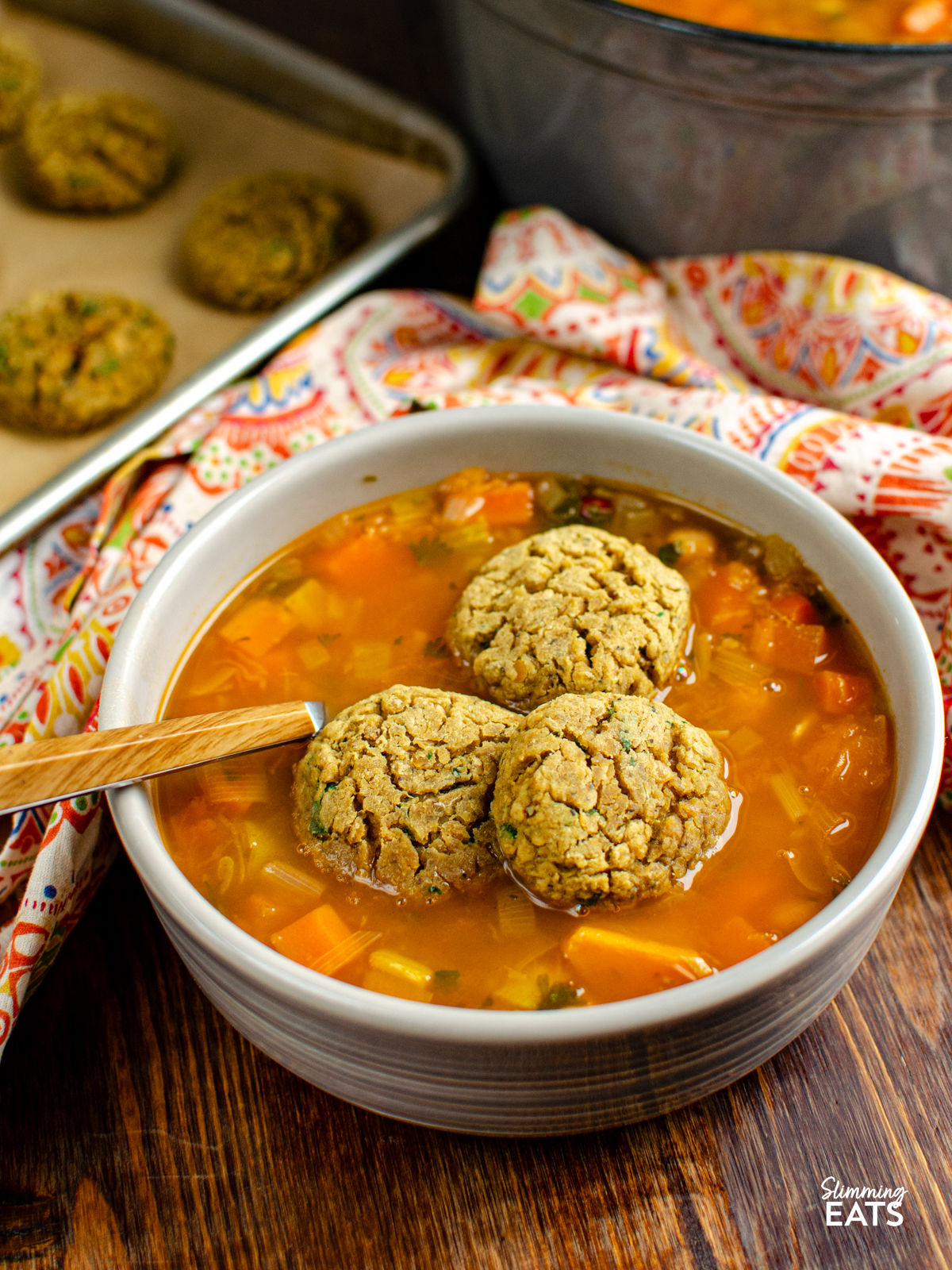 vegan lentil dumplings placed in a grey bowl with vegetable bean stew