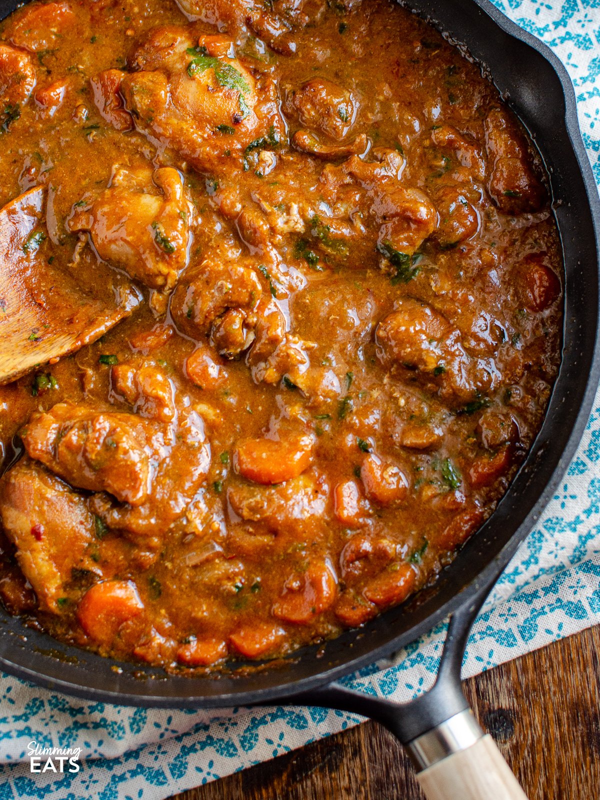 close up of Homemade Sweet and Spicy Ginger Chicken in a black frying pan with wooden handle