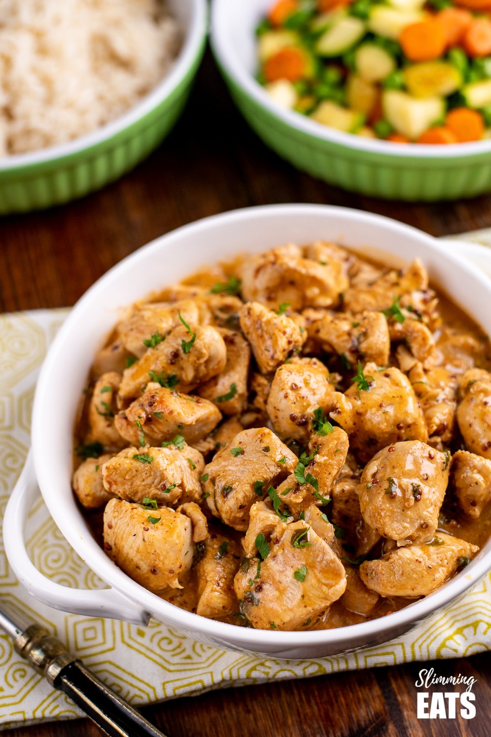 instant pot honey mustard chicken in white dish, with rice and vegetable in background