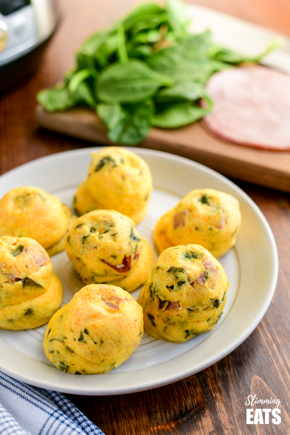 Instant Pot Sous Vide Egg Bites on plate with ham and spinach on wooden board