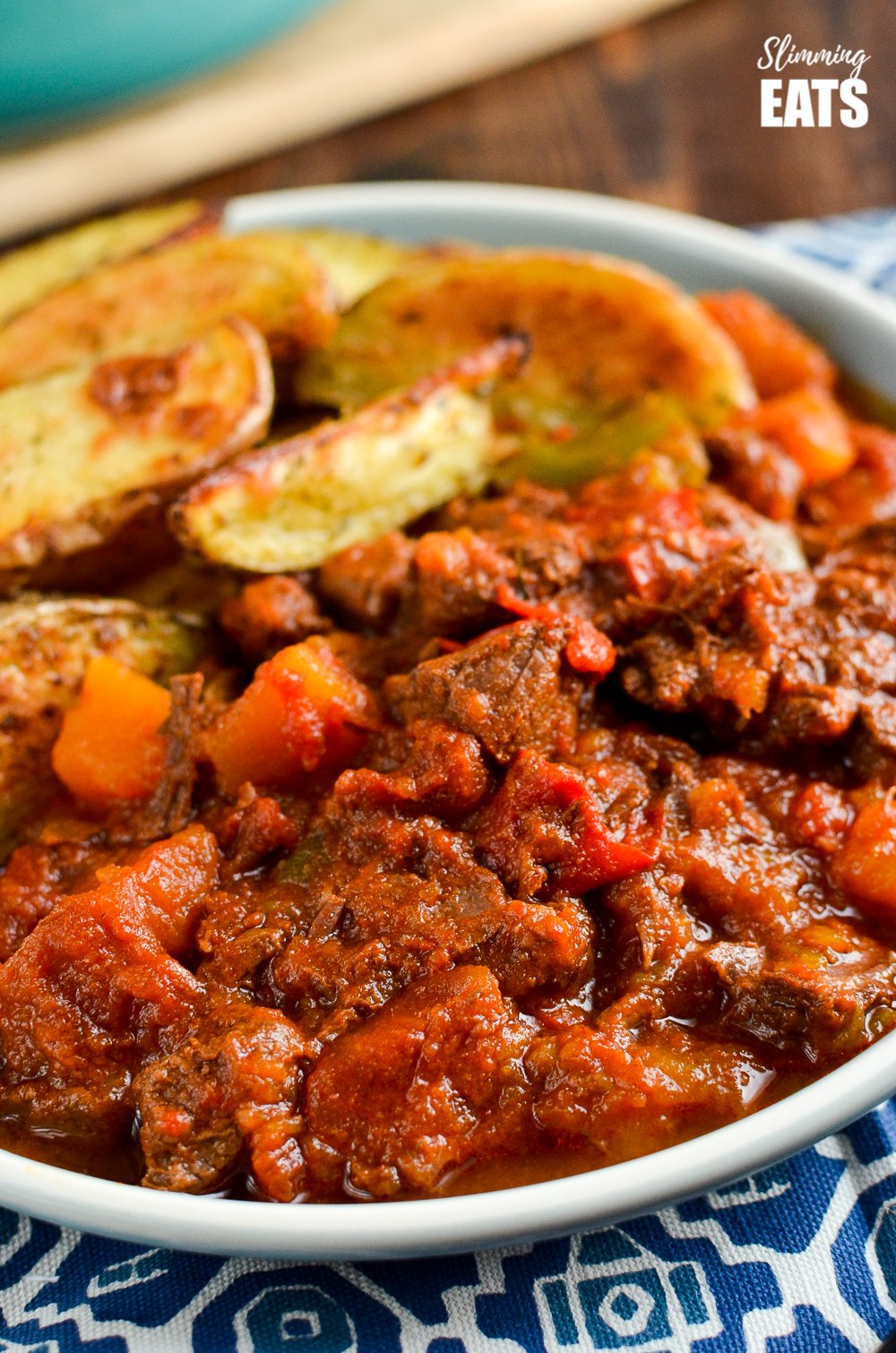 Paprika Beef - tender chunks of beef in a rich smokey paprika tomato sauce with chunks of butternut squash. #glutenfree #dairyfree #instantpot #slowcooker #slimmingeats #weightwatchers #beef close up of paprika beef on a plate with potato wedges