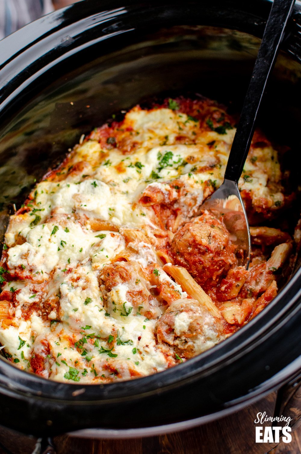 Slow Cooker Chicken Meatball Pasta Bake - a delicious recipe for easy tender chicken meatballs, combined with penne pasta and topped with ricotta and parmesan cheese. #slowcooker #slimmingeats #weightwatchers #chicken #pasta #crockpot #ricotta slow cooker chicken meatball pasta bake in slow cooker with spoon