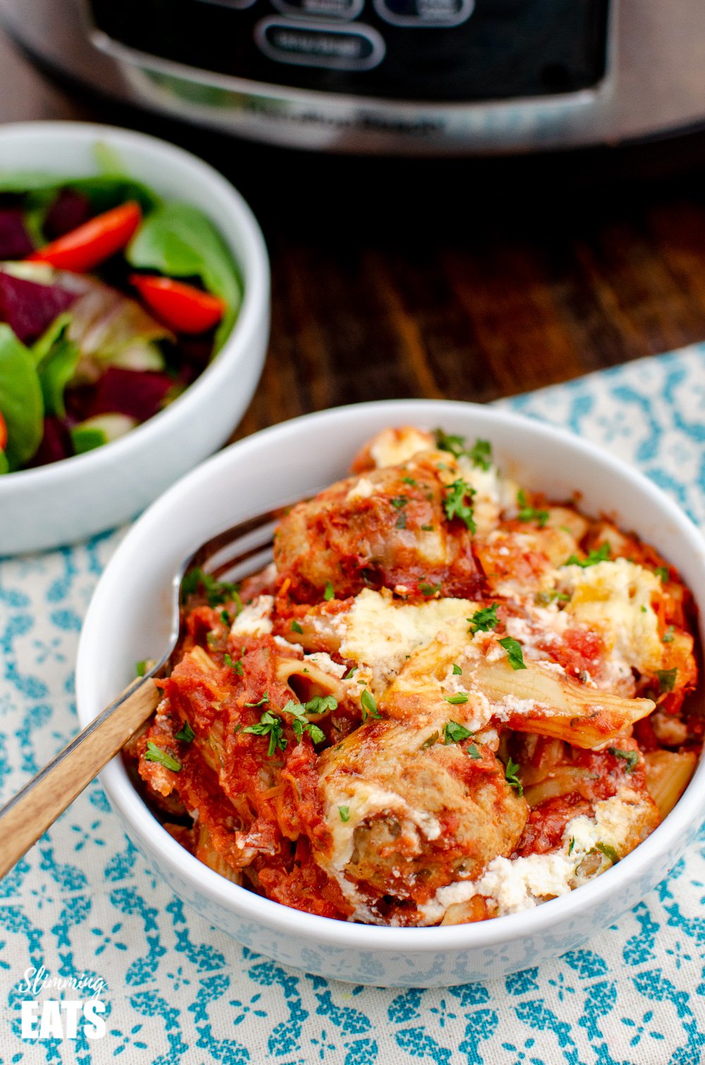 Slow Cooker Chicken Meatball Pasta Bake - a delicious recipe for easy tender chicken meatballs, combined with penne pasta and topped with ricotta and parmesan cheese. #slowcooker #slimmingeats #weightwatchers #chicken #pasta #crockpot #ricotta serving of slow cooker chicken meatballs pasta bake in white bowl with fork