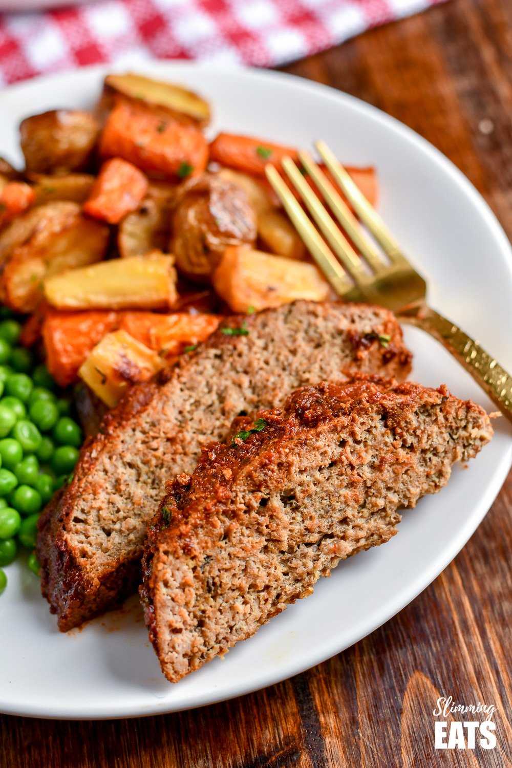 Slow Cooker Chicken Mushroom Meatloaf - a super easy recipe for a tender delicious meatloaf with the yummy rich flavour of mushrooms all topped with a delicious tomato glaze. 2 slices of slow cooker chicken mushroom meatloaf on white plate with roasted vegetables and peas