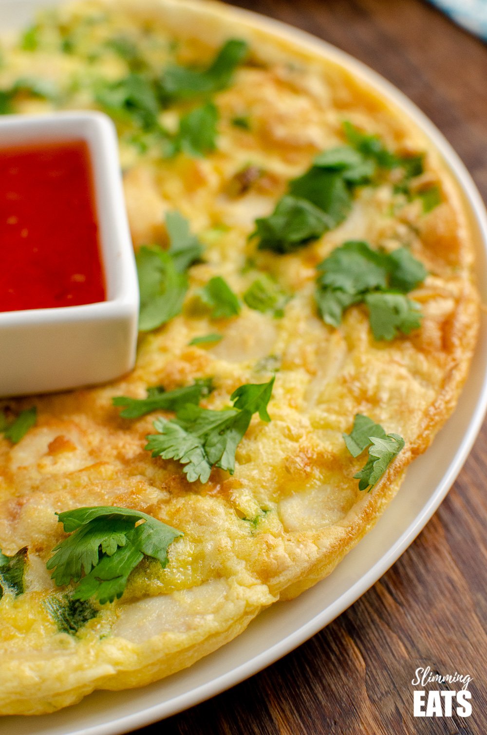 thai chicken omelette on white plate with Thai dipping sauce