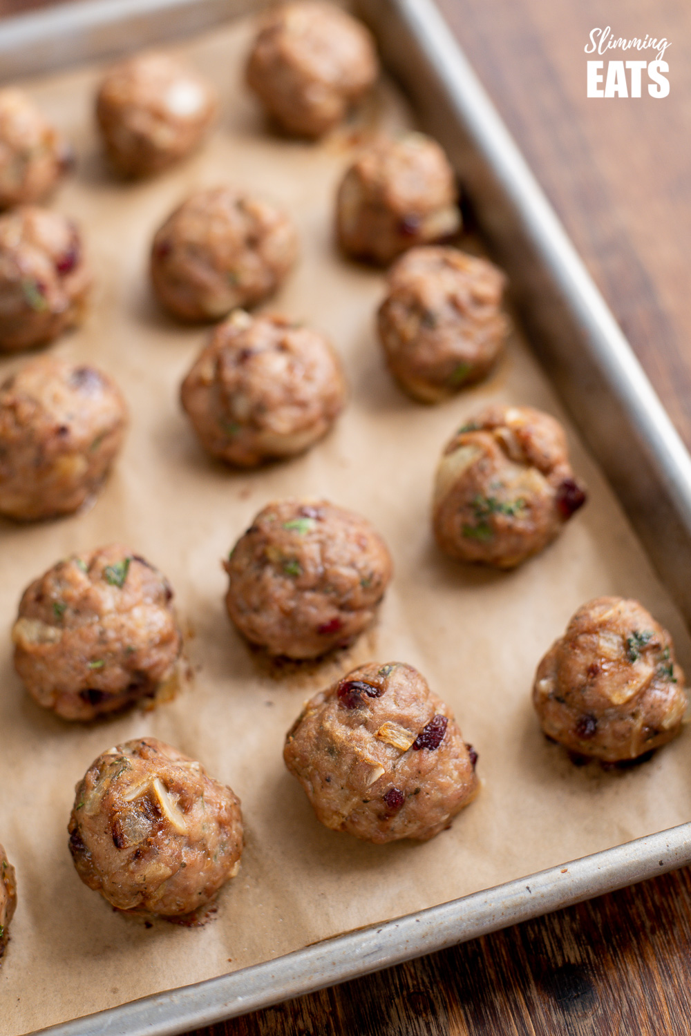close up of cranberry almond chicken meatballs on a baking tray