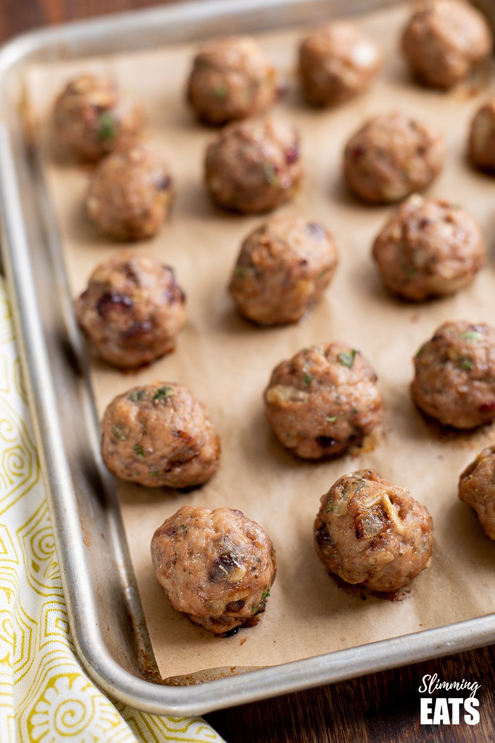 Cranberry Almond Chicken Meatballs - delicious protein bites with sliced almonds and the yummy sweetness of dried cranberries. Gluten Free, Dairy Free, Slimming Eats and Weight Watchers friendly cranberry almond chicken meatballs on a parchment paper lined baking tray