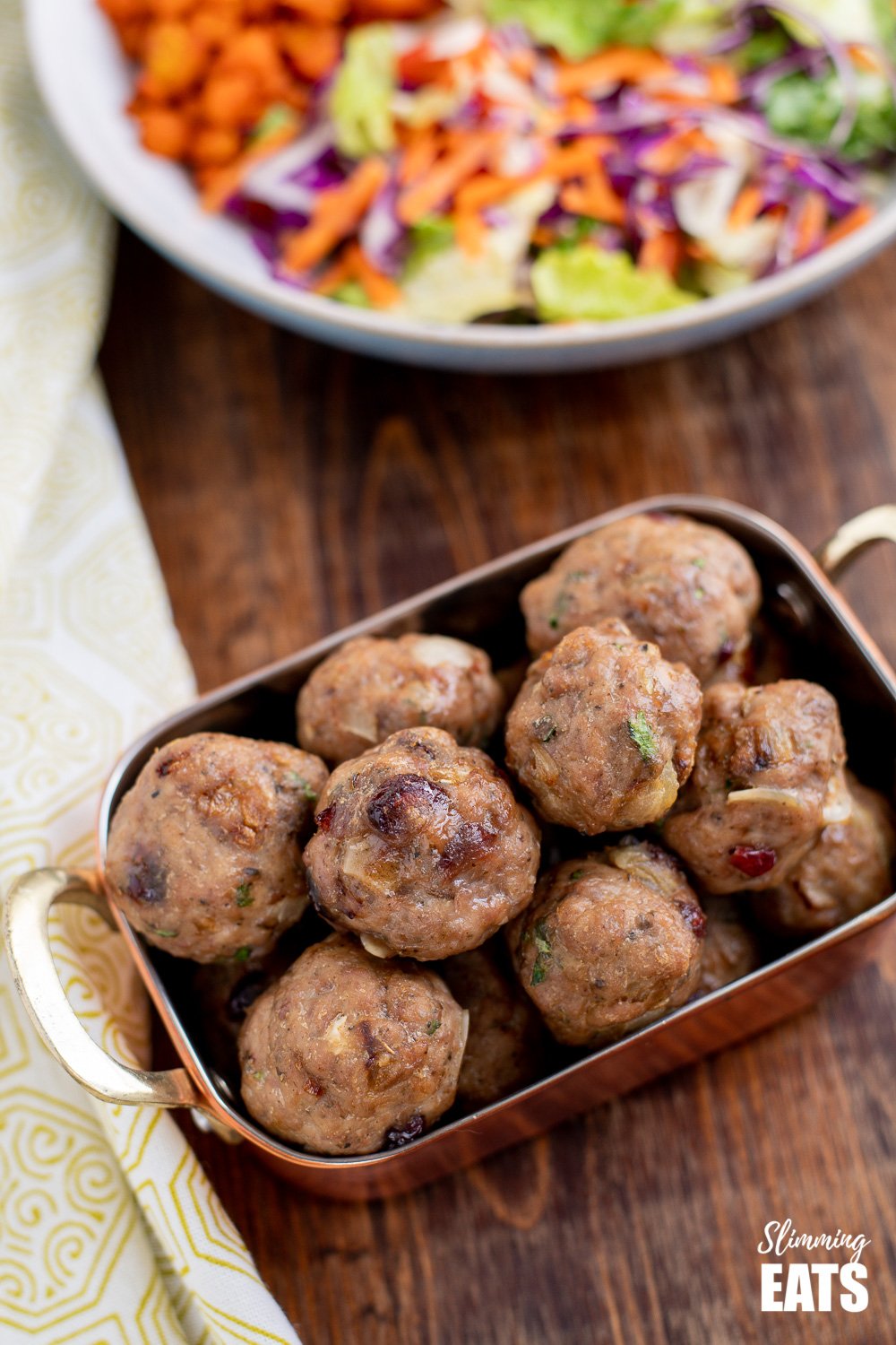 Cranberry Almond Chicken Meatballs - delicious protein bites with sliced almonds and the yummy sweetness of dried cranberries. Gluten Free, Dairy Free, Slimming Eats and Weight Watchers friendly close up of cranberry almond chicken meatballs in a copper dish