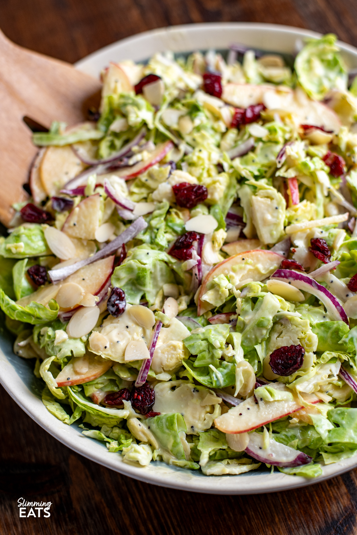 Brussels Sprouts Salad in a bowl with wooden salads mixers