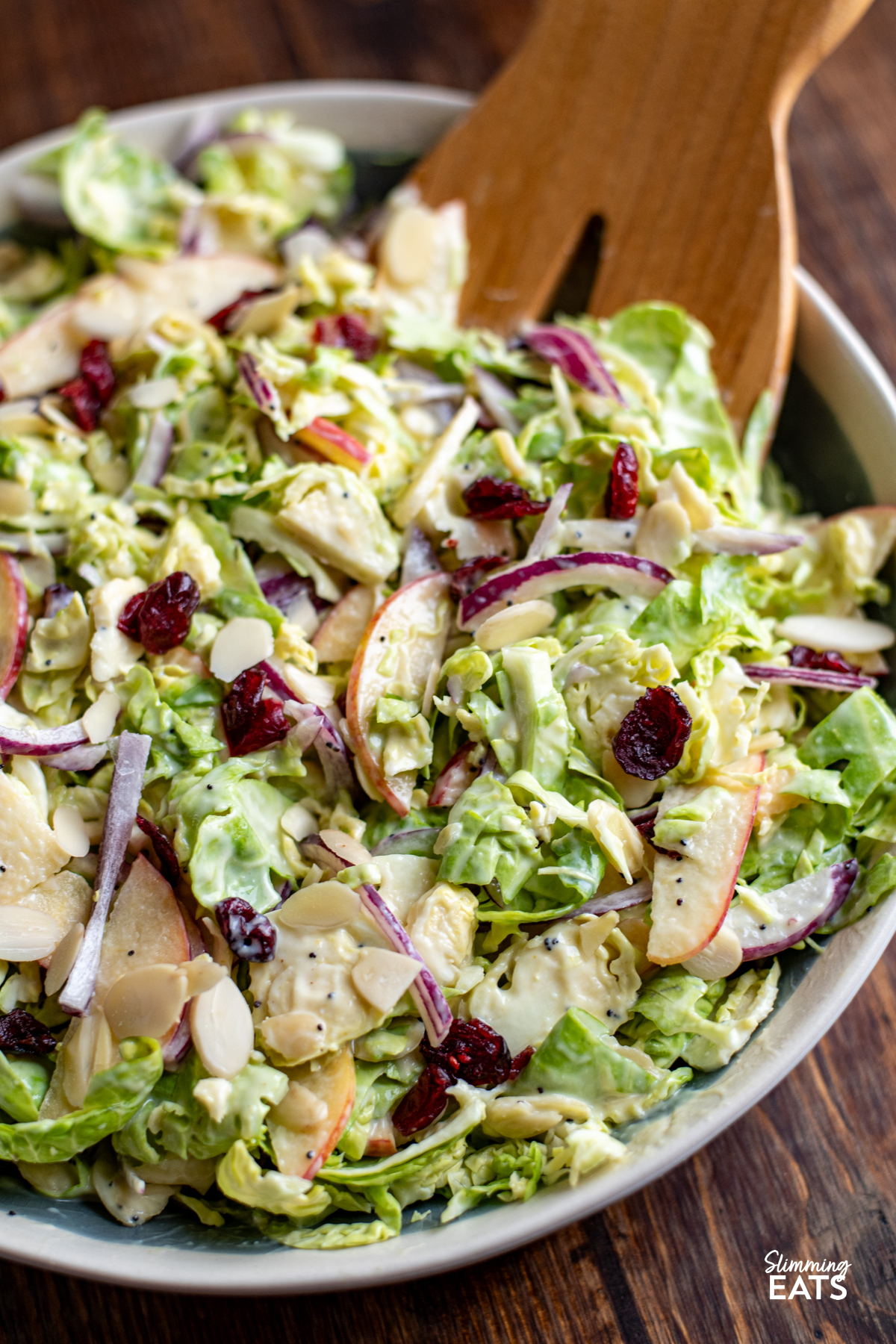 Brussels Sprouts Salad in a bowl with wooden salads mixers