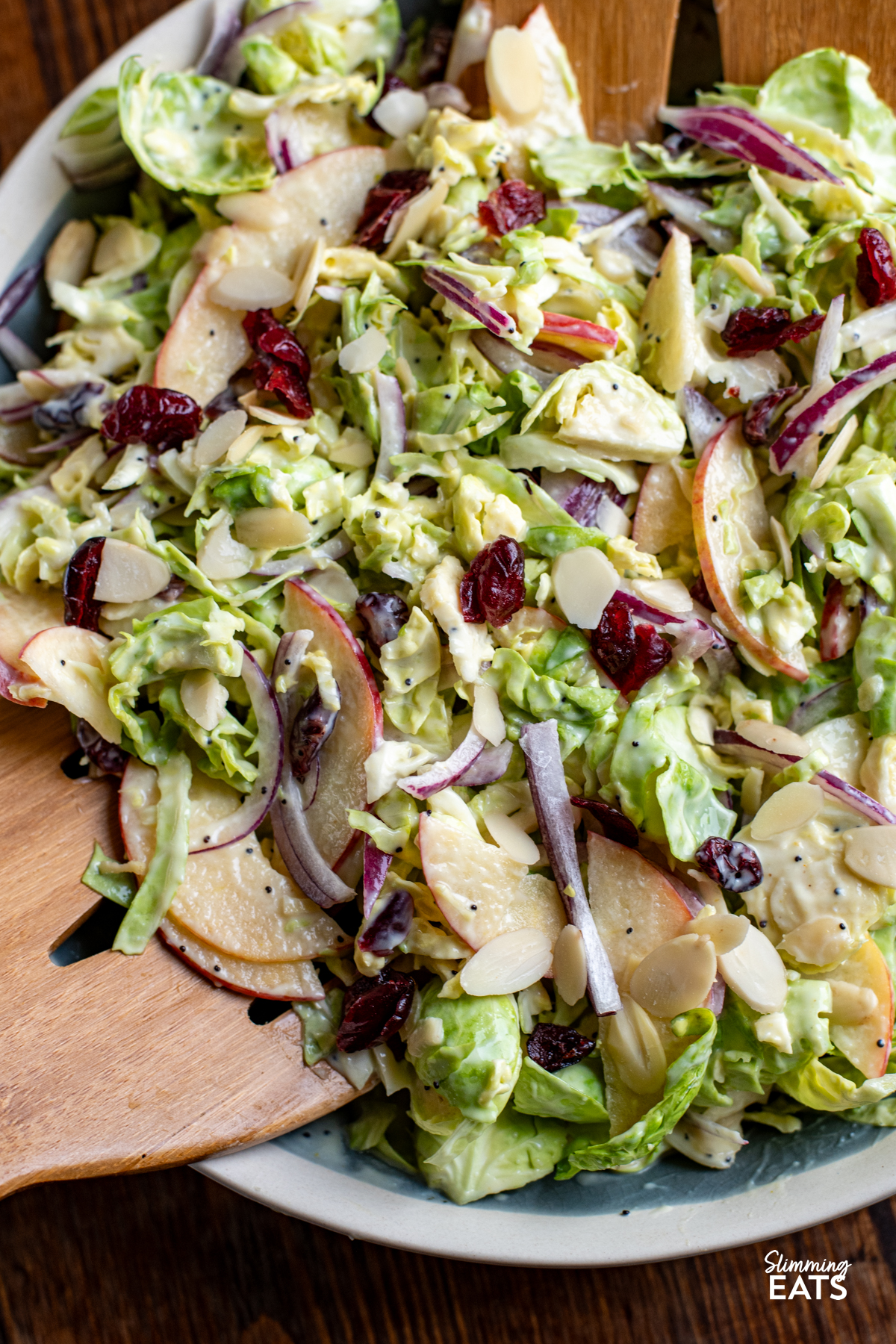 Brussels Sprouts Salad in a bowl with wooden salads mixers
