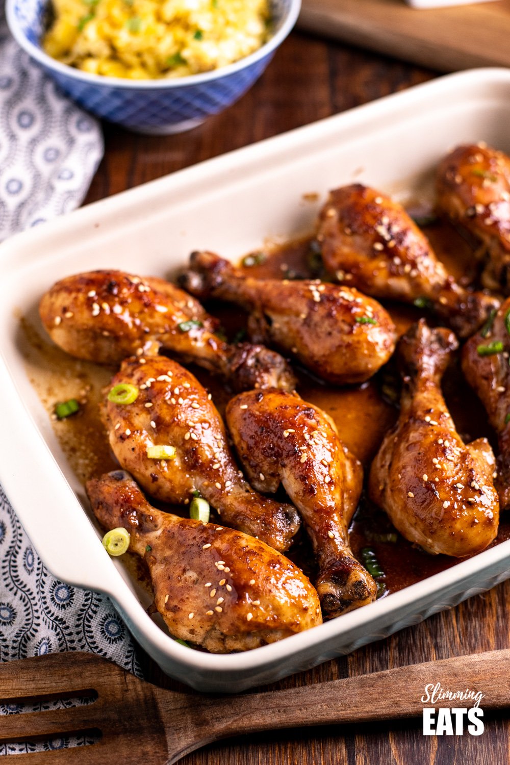 Chinese five spice chicken drumsticks in an oven proof dish on wooden board