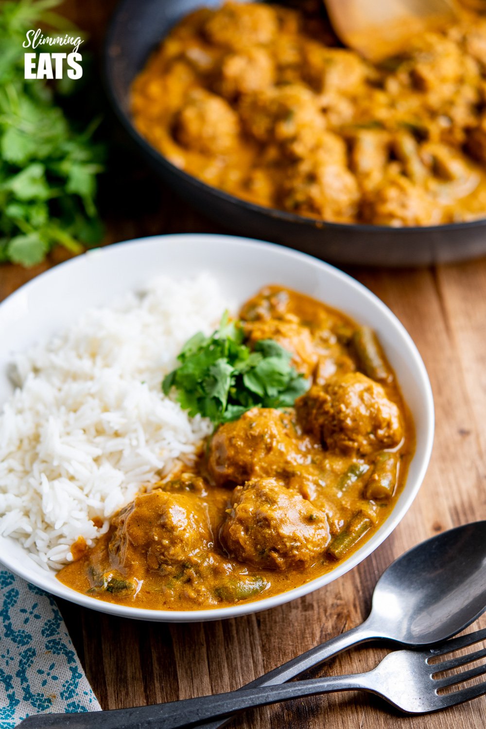 A Creamy Coconut Beef Meatball Curry - delicious tender meatballs with hidden veg in an amazing coconut sweet potato sauce. Gluten free, dairy free, paleo, whole30, Slimming and Weight Watchers friendly coconut beef meatballs curry in white bowl with rice and coriander