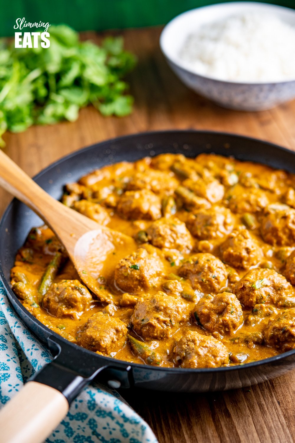 A Creamy Coconut Beef Meatball Curry - delicious tender meatballs with hidden veg in an amazing coconut sweet potato sauce. Gluten free, dairy free, paleo, whole30, Slimming and Weight Watchers friendly coconut beef meatball curry in black frying pan with wooden handle