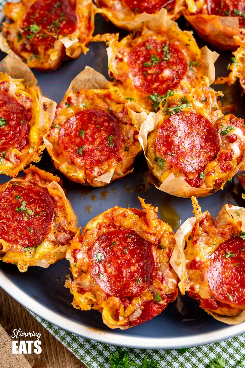 Drool-worthy Pepperoni Pizza Egg Bites - the mini cheesy bites are perfect for parties, tasters, lunches. Slimming and Weight Watchers friendly batch of Pepperoni Pizza Egg Bites on a blue plate