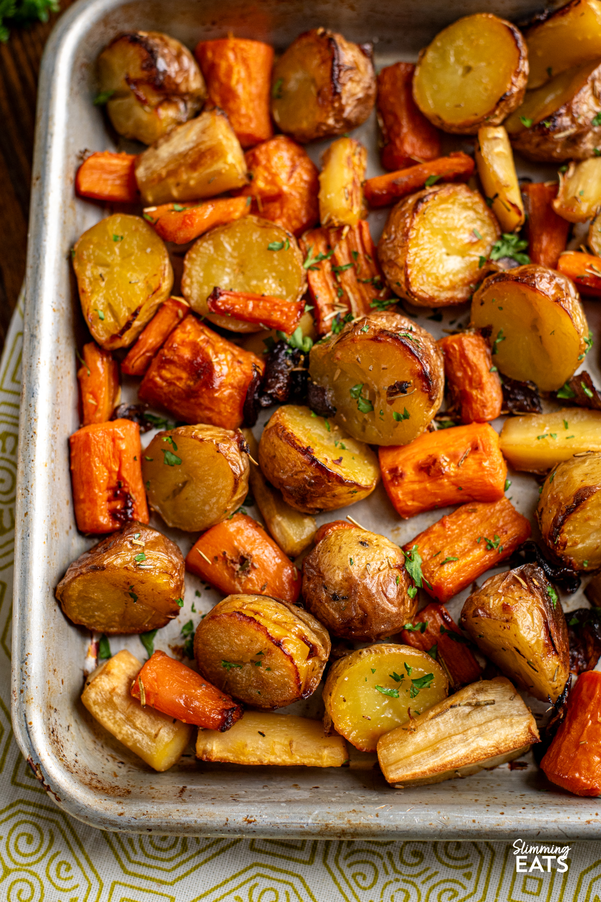 close up of Rosemary Roasted Potatoes, Parsnips, Carrots and Onion on baking tray