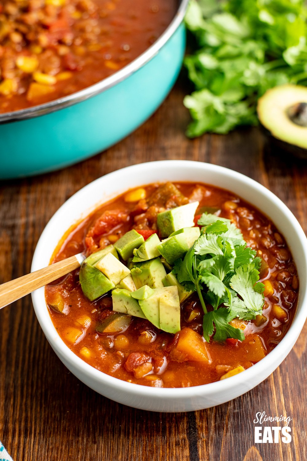 taco lentil soup in white bowl with wooden handles spoon