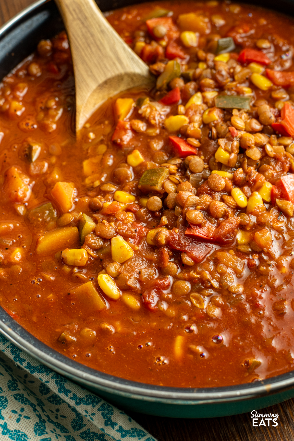 Taco Lentil Soup - the delicious spicy flavour of tacos using lentils instead of meat for a filling hearty meal that even the kids will enjoy. Gluten Free, Dairy Free, Vegan, Slimming and Weight Watchers friendly close up of taco lentil soup in frying pan with wooden spoon.