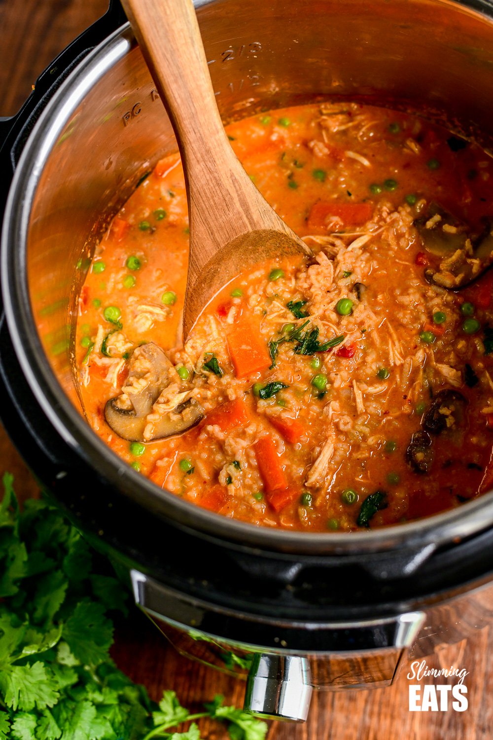 Thai chicken rice soup in instant pot with wooden spoon