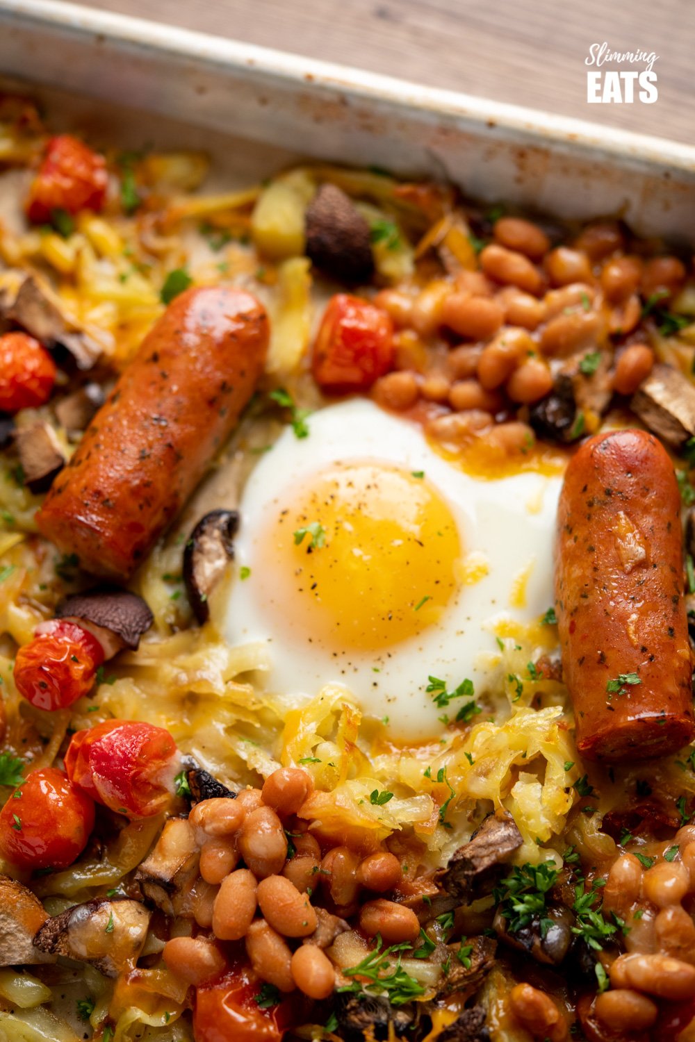The Ultimate All Day Breakfast Tray Bake - so delicious, you will enjoy this easy simple recipe any time of day. Gluten Free, Vegetarian, Slimming Eats and Weight Watchers friendly close up of fried egg on a parchment lined baking tray