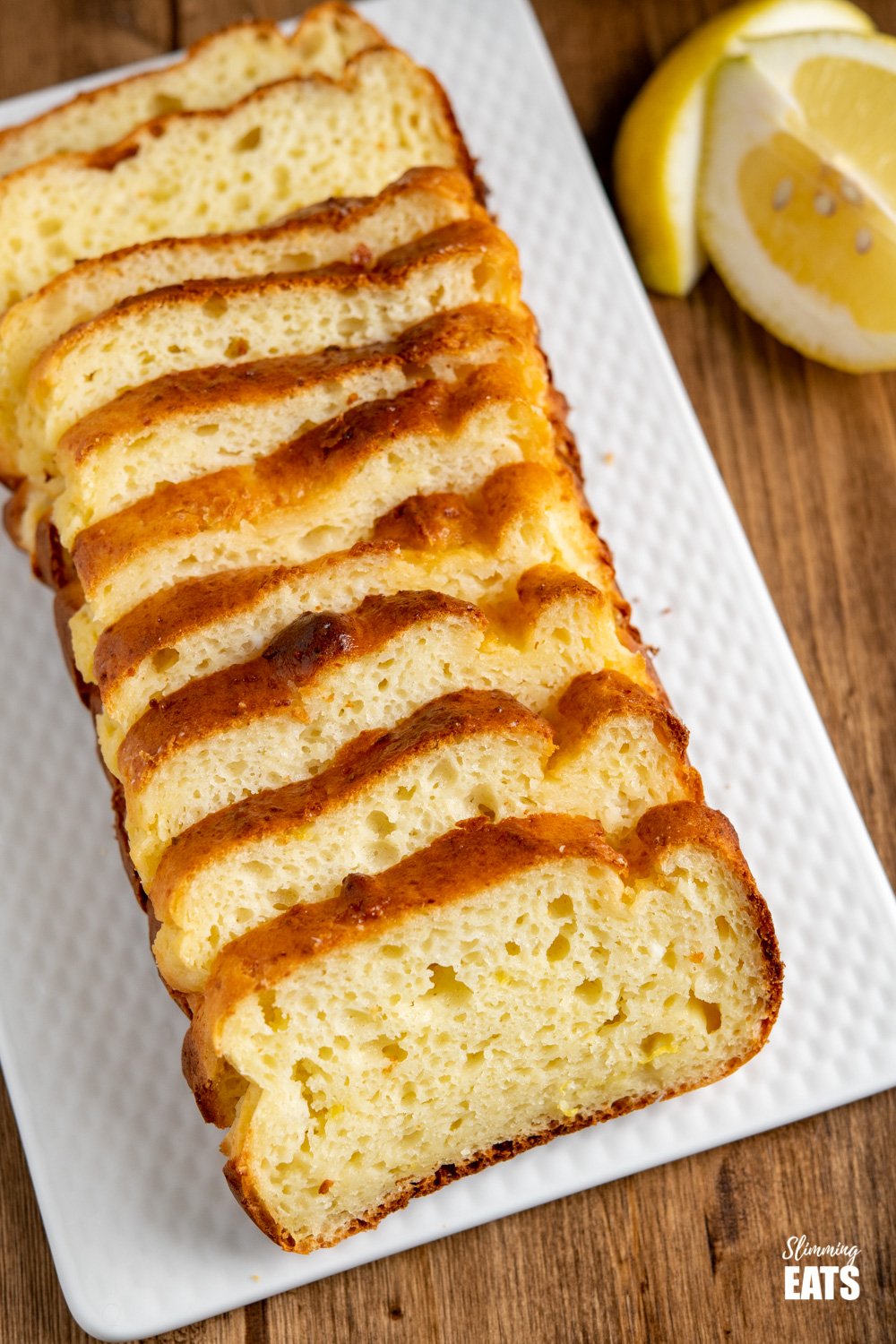 close up of sliced lemon loaf on white plate