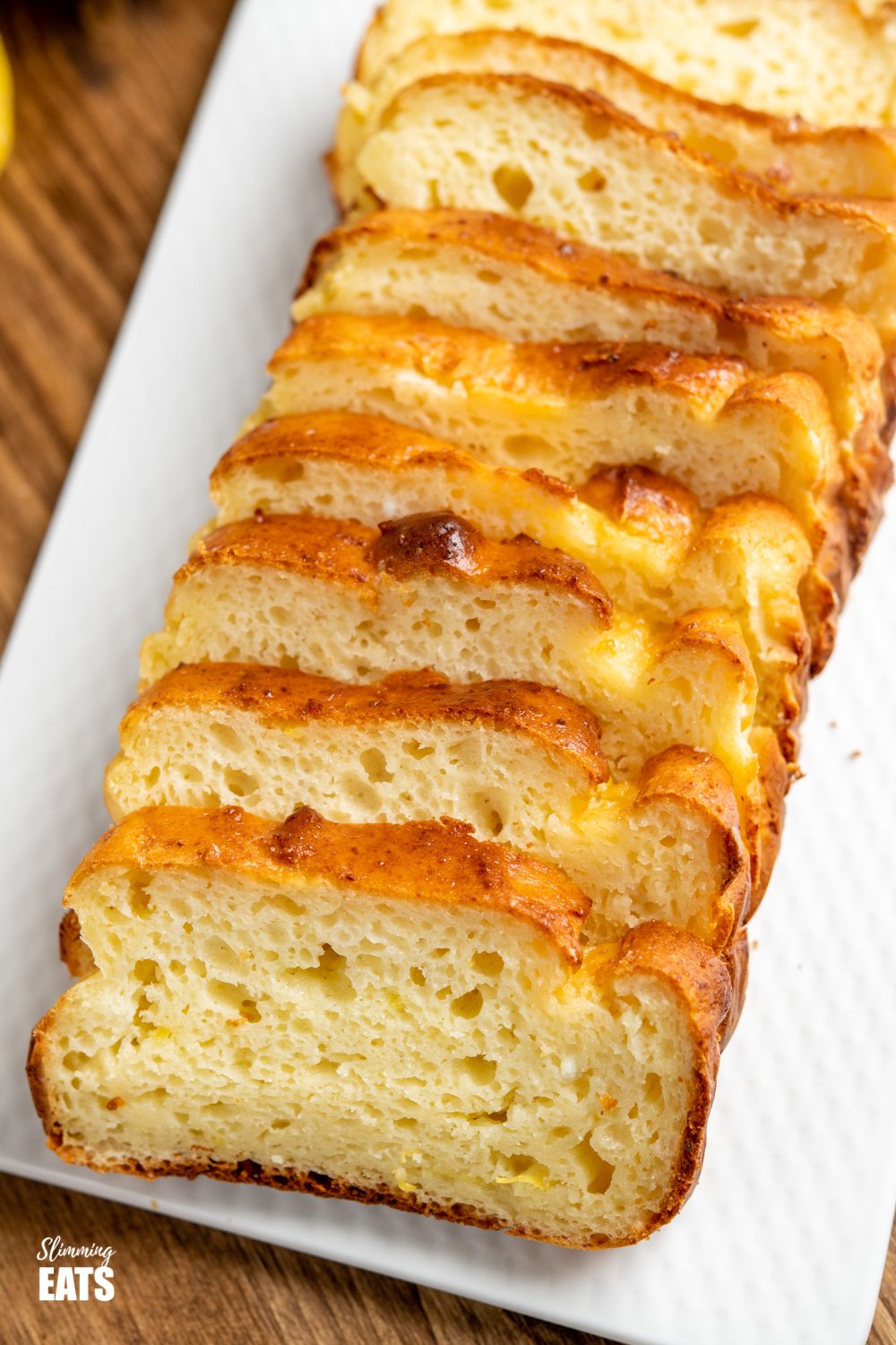 close up of sliced lemon ricotta loaf on white plate