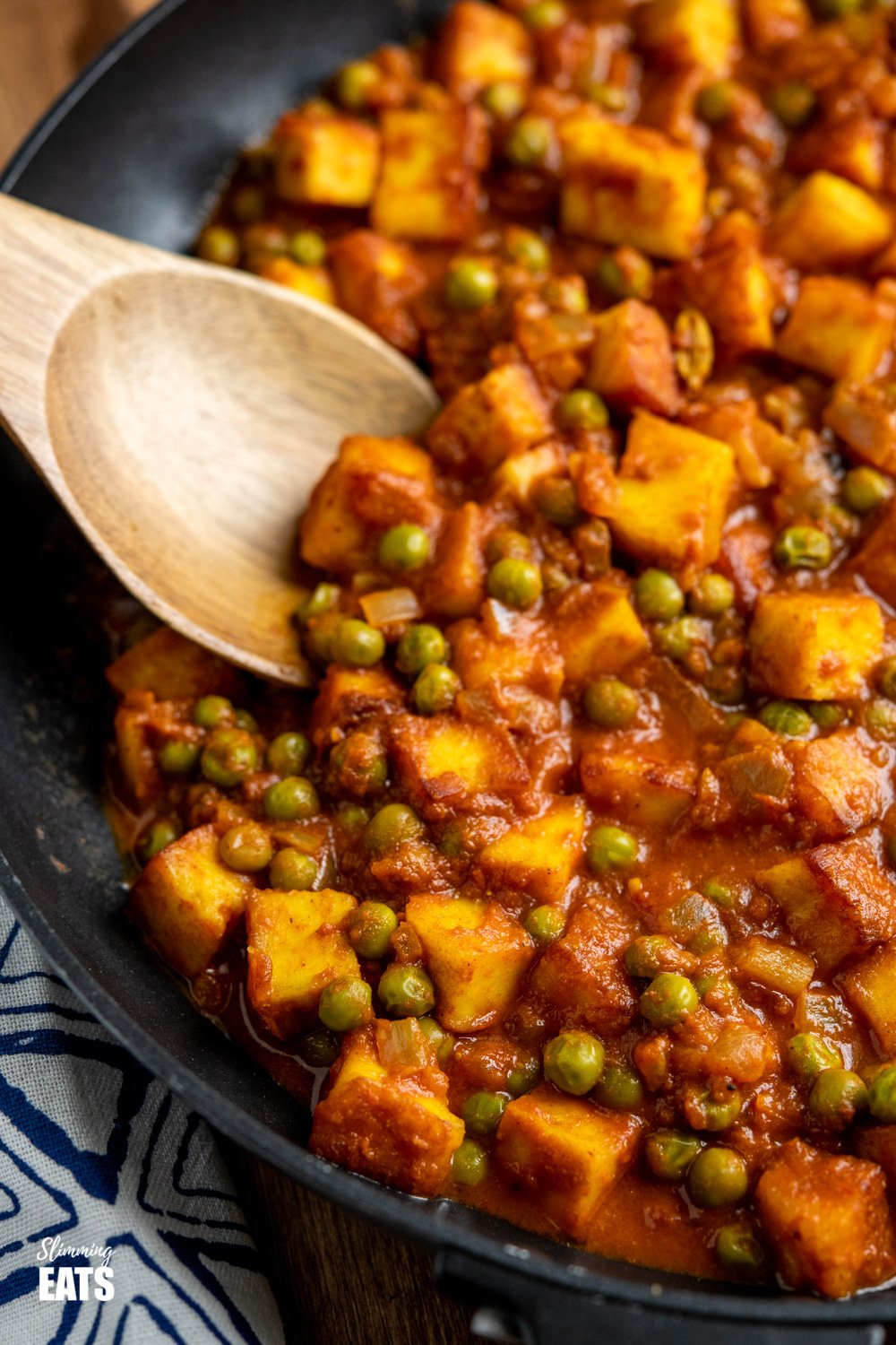 close up of matar paneer curry in black frying pan