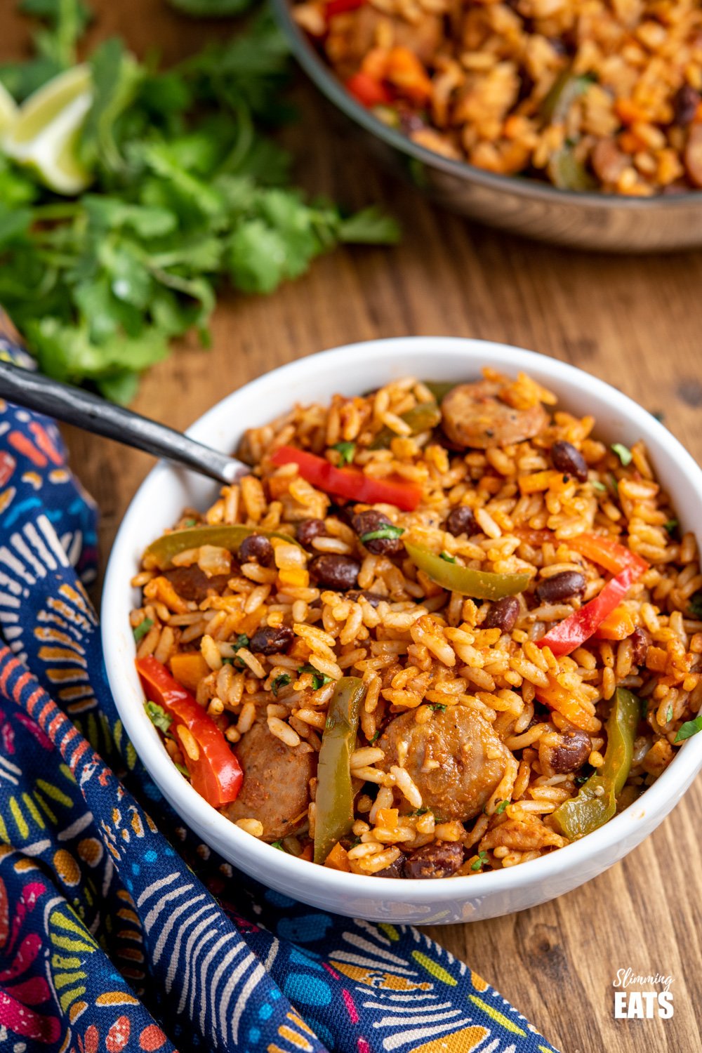 One Pot Cuban Style Rice (with Chicken and Sausage) - this delicious one-pot recipe with spicy seasonings, fresh vegetables and black beans is a perfect meal for any night of the week. Gluten Free, Dairy Free, Slimming Eats and Weight Watchers friendly One Pot Cuban Style Rice in white bowl with black handled fork
