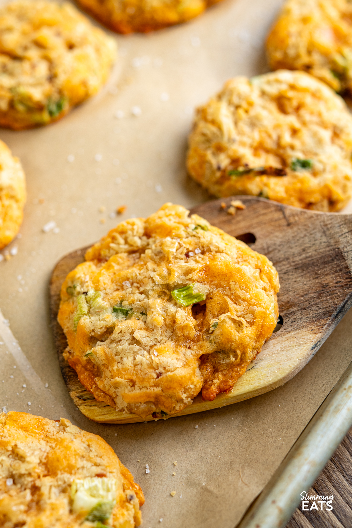 Cheddar Butter Bean Bites on a parchment lined tray with wooden spatula