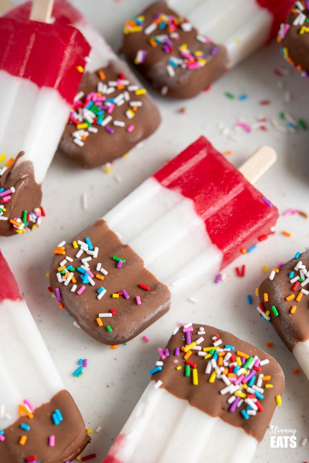 close up of fab ice lolly on a white board with scattered ice lollies around it