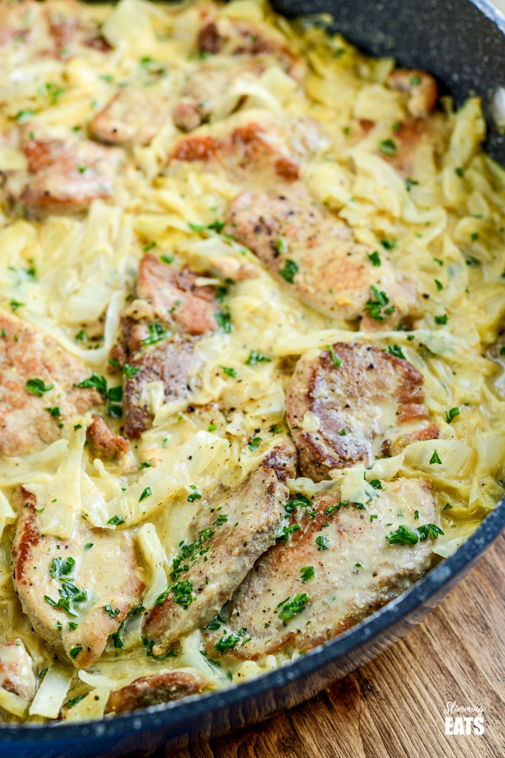 close up of creamy garlic pork with cabbage in frying pan