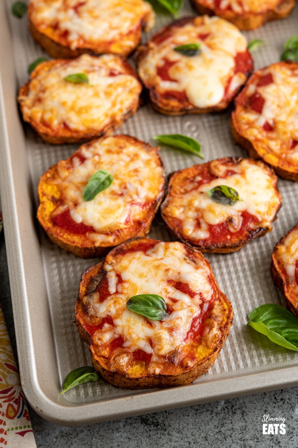 Delicious Cheesy Air Fryer Pizza Sweet Potato Slices - because all the pizza lovers out there should turn everything into Pizza. Gluten Free, vegetarian, Slimming Eats and Weight Watchers friendly close up of air fryer pizza sweet potato slices on a baking tray