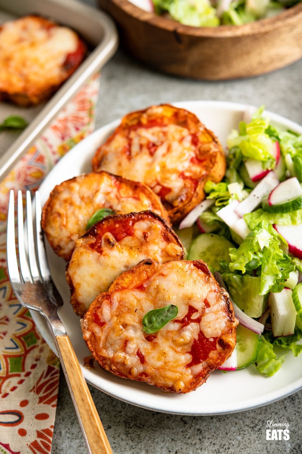 Delicious Cheesy Air Fryer Pizza Sweet Potato Slices - because all the pizza lovers out there should turn everything into Pizza. Gluten Free, vegetarian, Slimming Eats and Weight Watchers friendly Air Fryer Pizza Sweet Potato Slices with salad on white plate, fork placed to the left