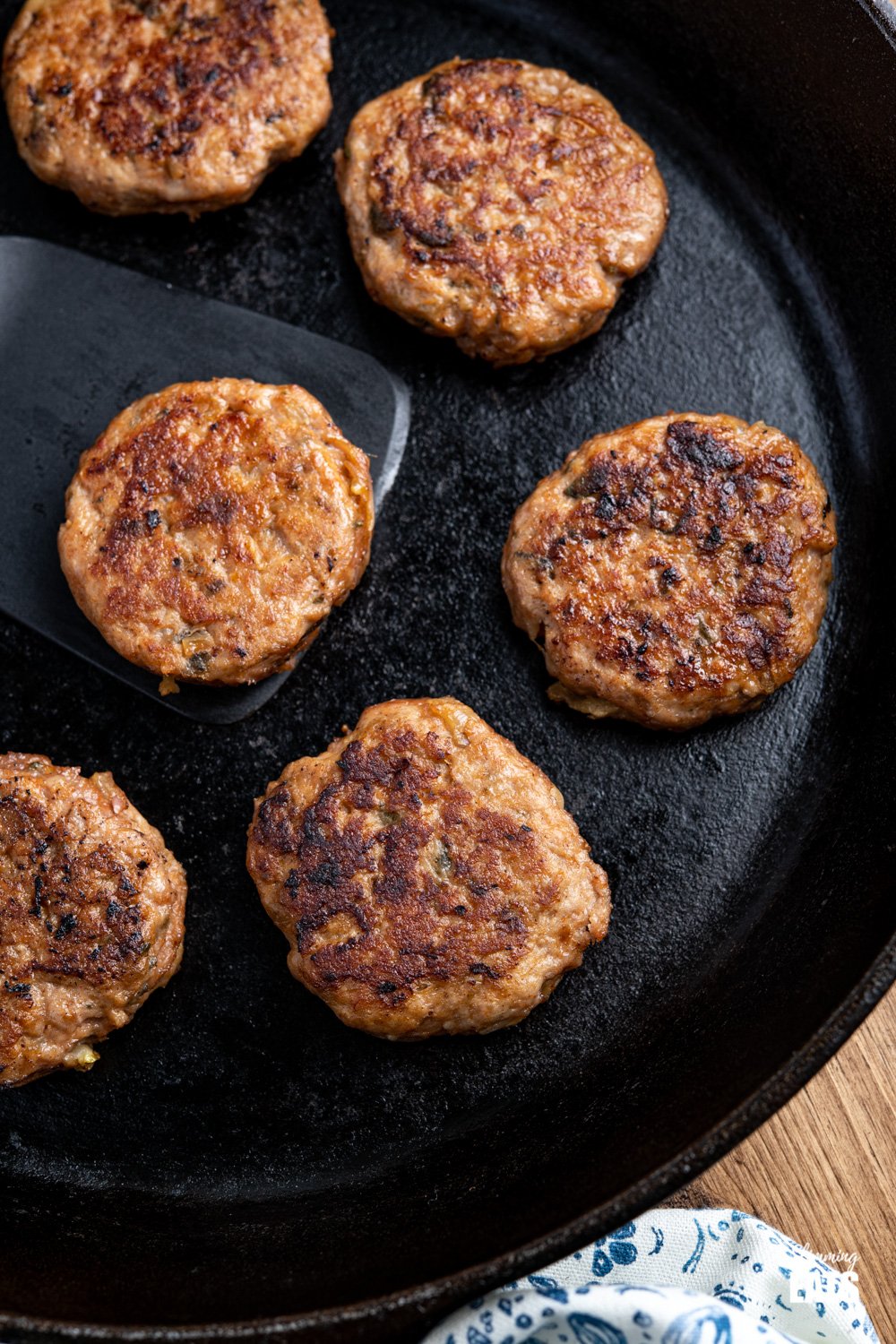 Delicious Homemade Turkey Breakfast Sausage Patties - tasty simple ingredients and the perfect way to start the day with your choice of eggs or other breakfast sides. Gluten free, dairy free, Slimming Eats and Weight Watchers friendly close up of cooked Turkey Breakfast Sausage Patties in a lodge cast iron skillet