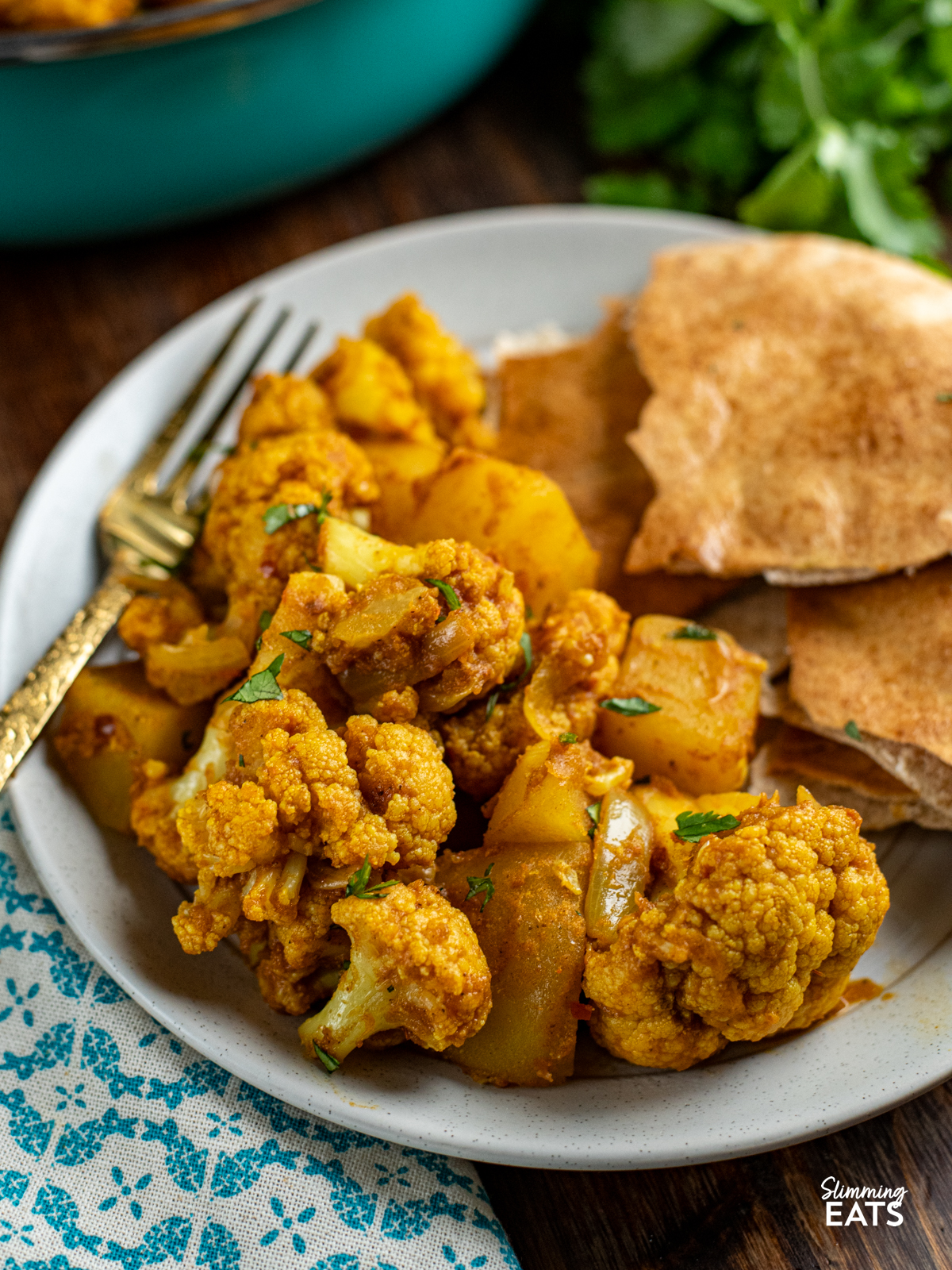 aloo gobi served up on a plate with pita bread
