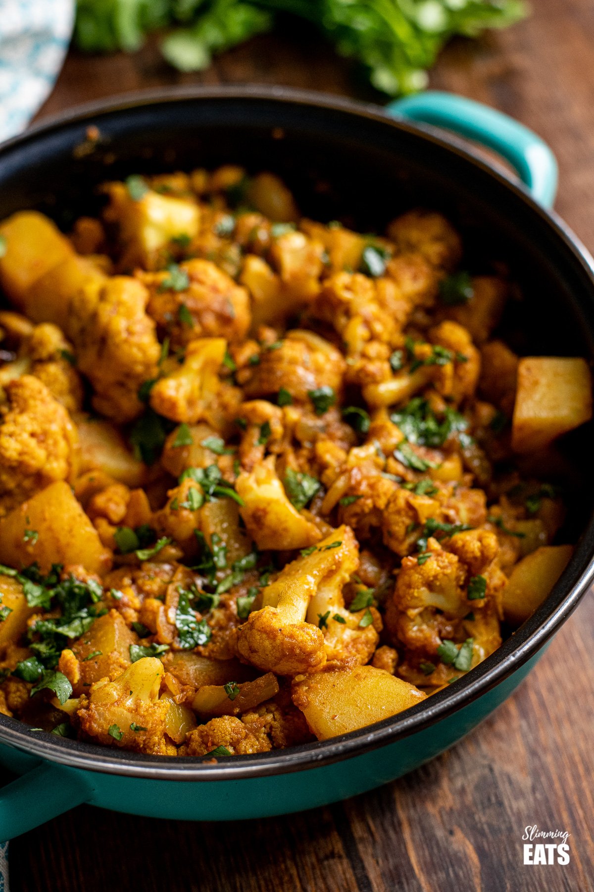 aloo gobi in frying pan with cilantro in background