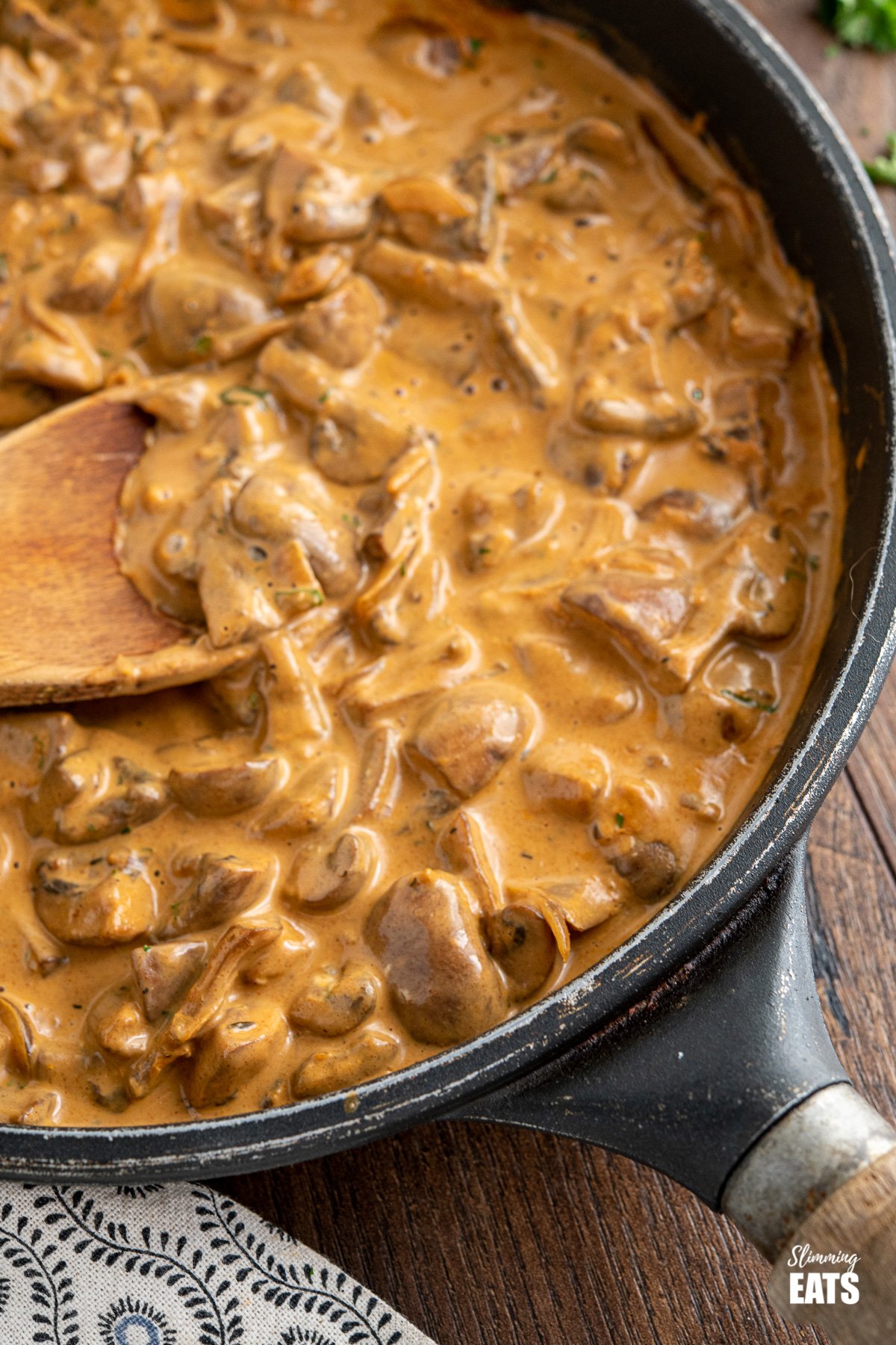 close up of Creamy Mushroom Stroganoff in black frying pan with wooden handle